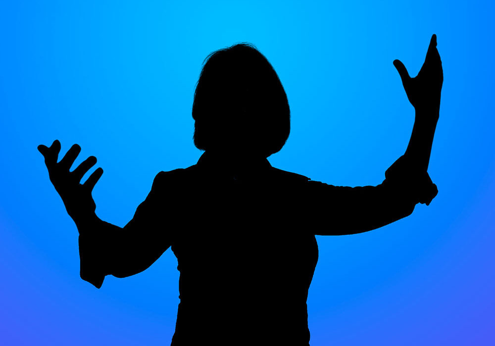 Silhouetted person with arms raised against a blue gradient background, conveying celebration or emphasis.